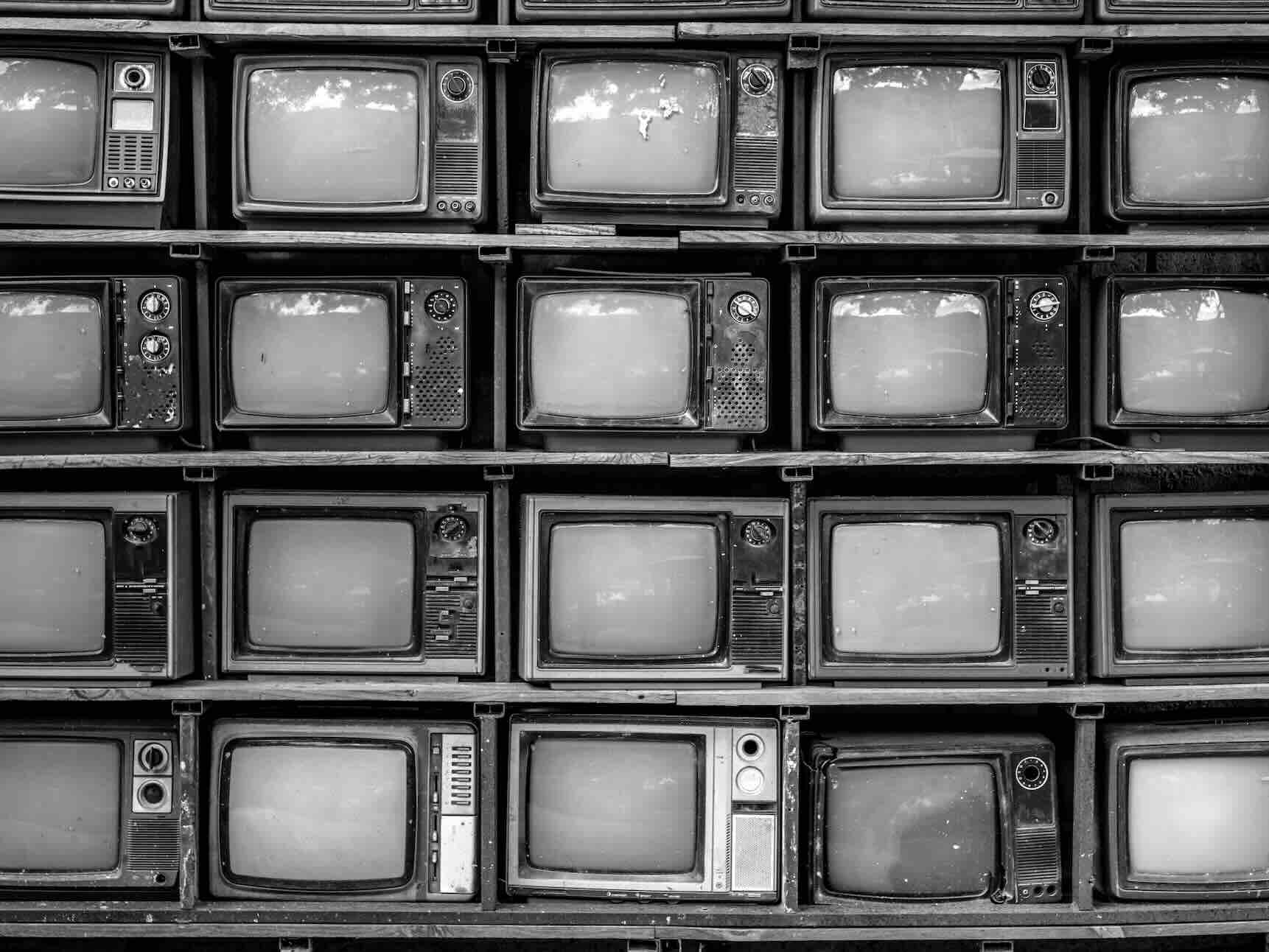 A black and white photo of a grid of stacked CRT television sets.