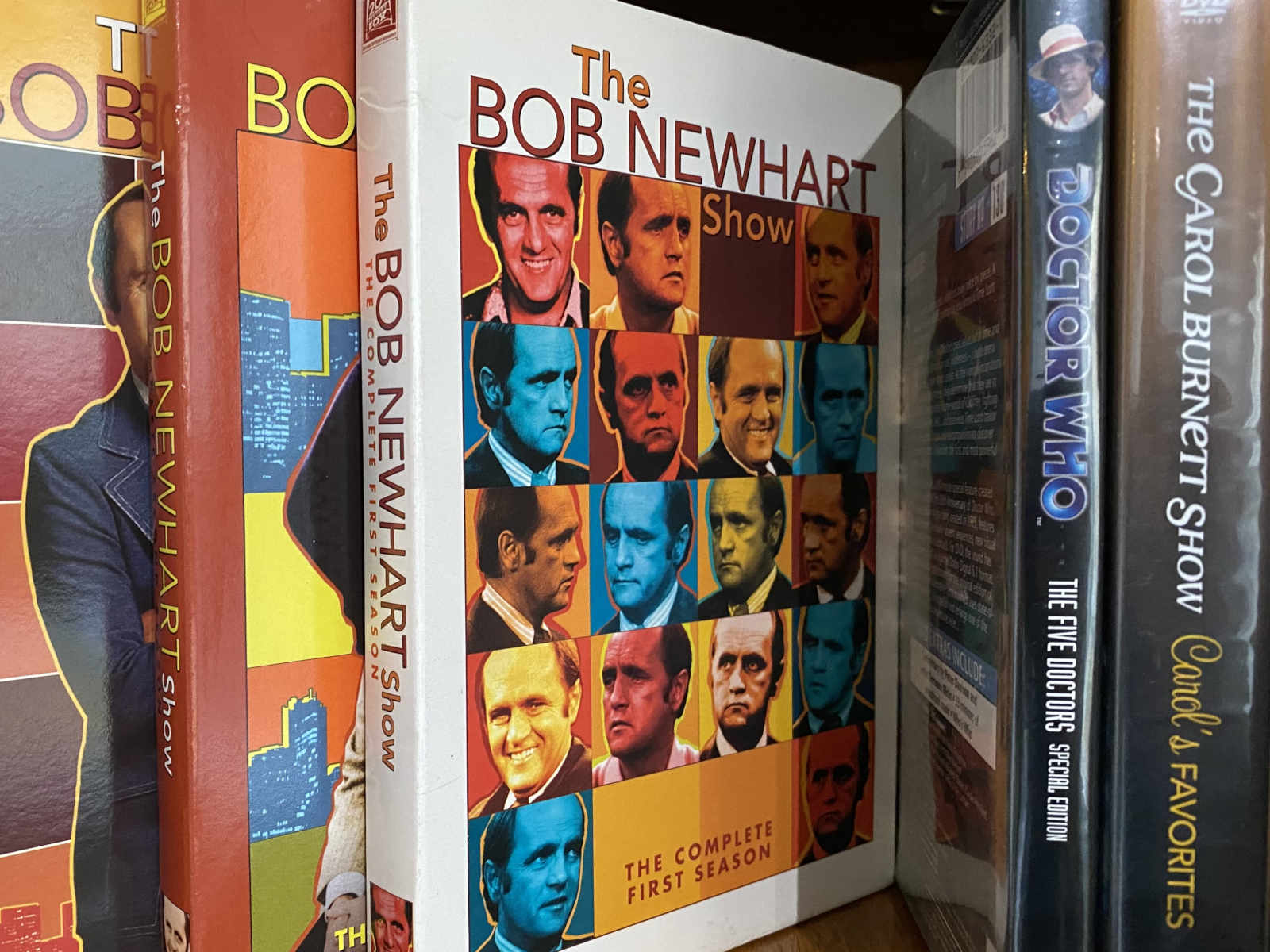 A shelf with DVDs of *The Bob Newhart Show*, *Doctor Who*, and *The Carroll Burnett Show*.