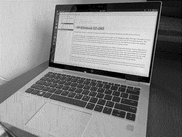A photo of the HP EliteBook mentioned in this blog post. It's sitting on a desk. The screen is open and it's showing a text editor with an earlier draft of this blog post.